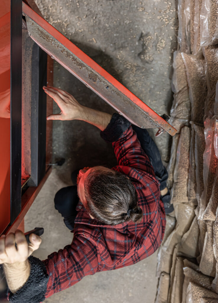 a man looking into a boiler on solid fuel, open door boiler with flames of fire.